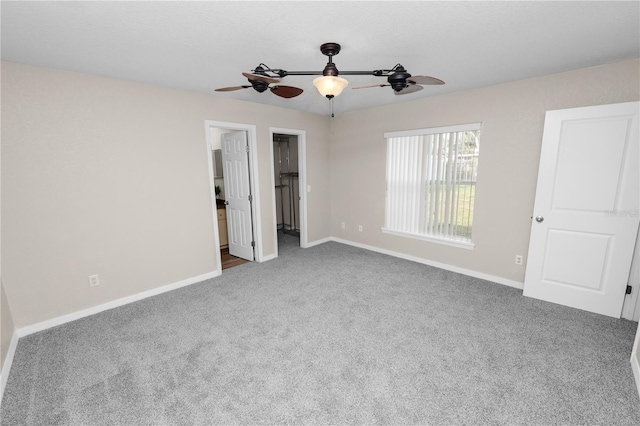 unfurnished bedroom featuring carpet flooring, ceiling fan, and a spacious closet