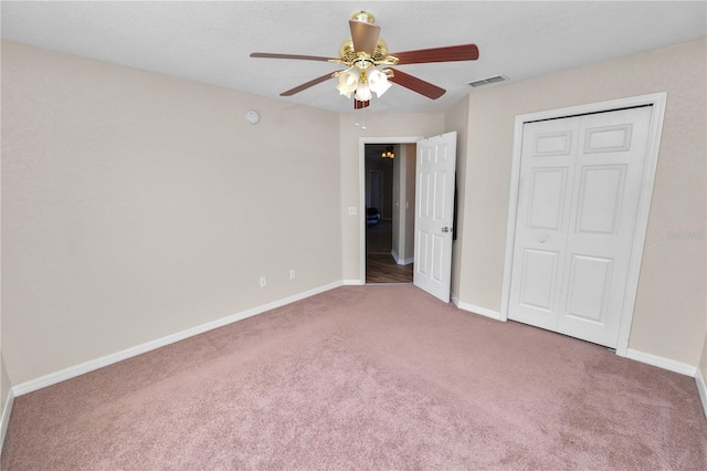 unfurnished bedroom featuring a closet, ceiling fan, and carpet flooring