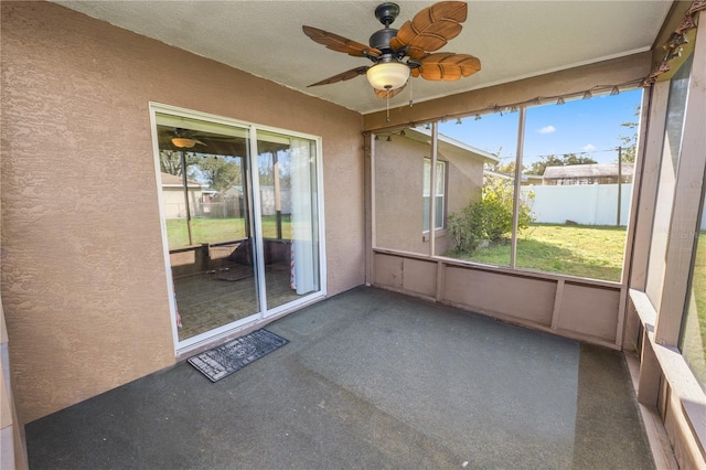 unfurnished sunroom featuring ceiling fan