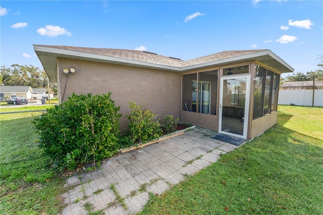 back of property featuring a sunroom and a yard