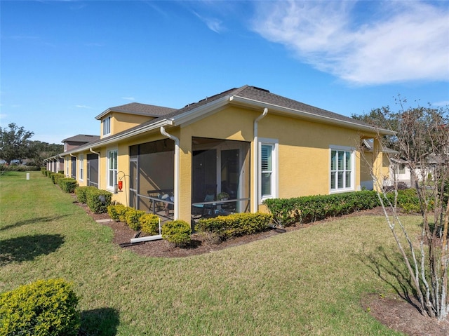 view of side of property featuring a yard and a sunroom