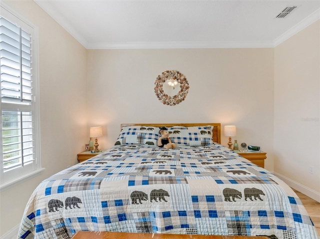 bedroom featuring ornamental molding and hardwood / wood-style floors