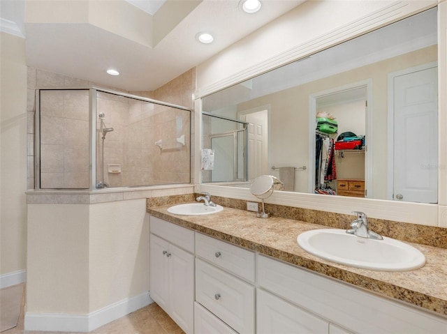 bathroom featuring a shower with door and vanity