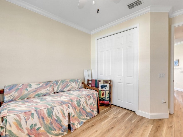 bedroom featuring crown molding, ceiling fan, light hardwood / wood-style floors, and a closet