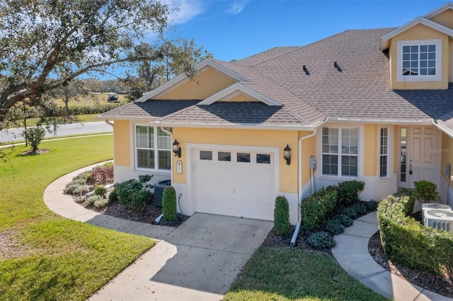 ranch-style home with cooling unit, a garage, and a front lawn