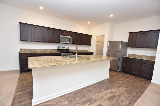 kitchen featuring stainless steel appliances, sink, a center island with sink, and dark brown cabinetry