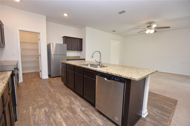 kitchen featuring sink, dark brown cabinets, a center island with sink, dark hardwood / wood-style flooring, and stainless steel appliances