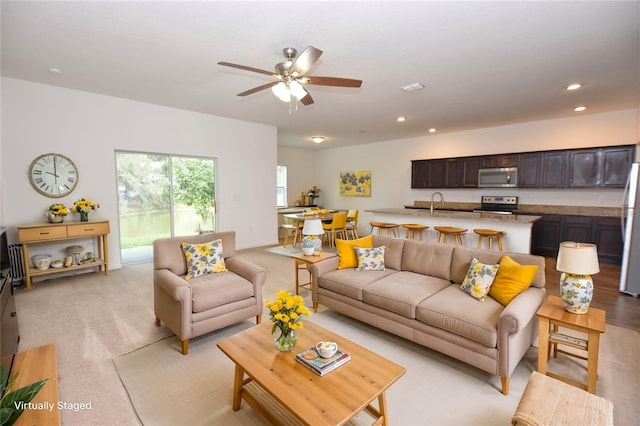 living room featuring ceiling fan and sink