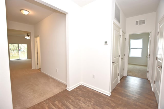 hall featuring dark colored carpet