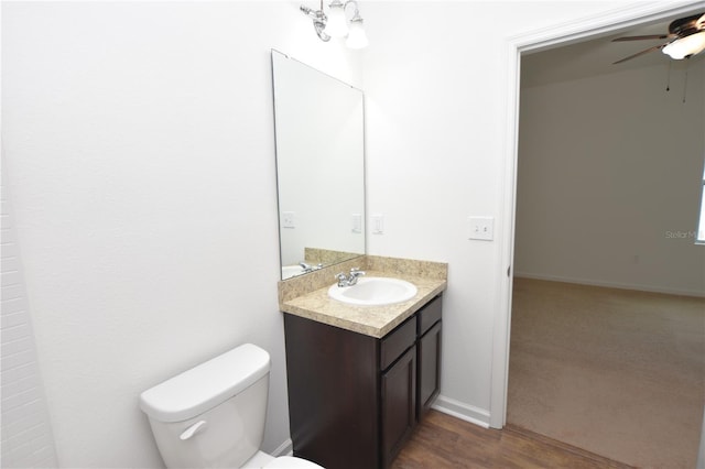 bathroom featuring vanity, ceiling fan, wood-type flooring, and toilet