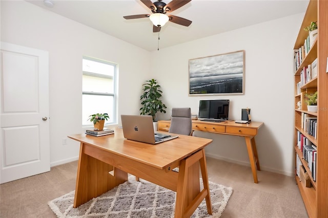 carpeted office space featuring ceiling fan