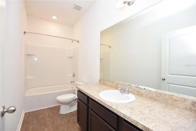 full bathroom featuring vanity, hardwood / wood-style flooring, bathtub / shower combination, and toilet