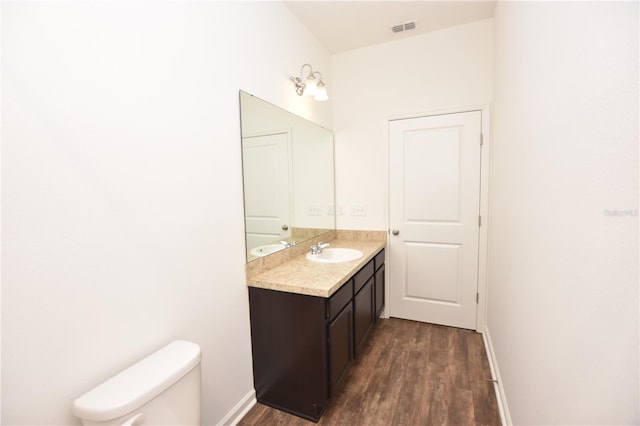 bathroom featuring vanity, wood-type flooring, and toilet