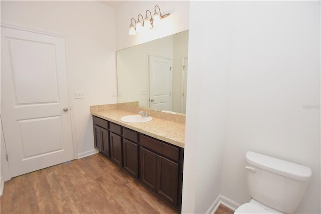 bathroom featuring vanity, wood-type flooring, and toilet