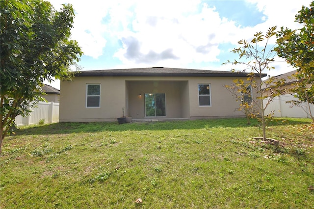 back of house featuring a lawn