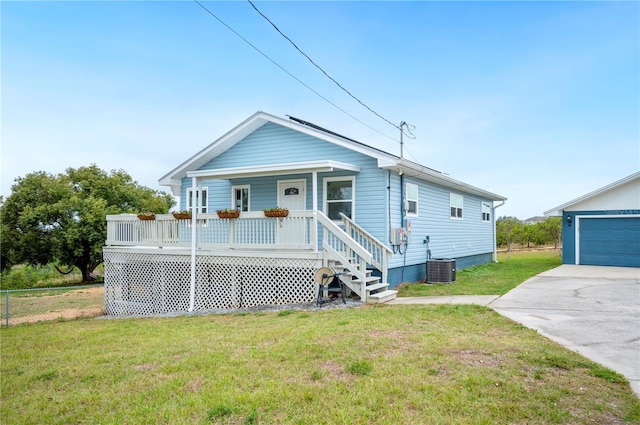 view of front of property featuring a garage, central air condition unit, covered porch, and a front lawn