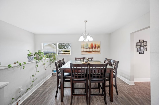 dining area featuring a notable chandelier and dark wood-type flooring