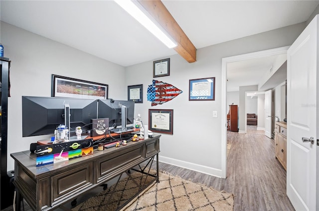 home office with wood-type flooring and beam ceiling