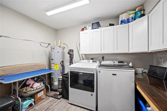 laundry area with cabinets, washing machine and dryer, electric water heater, and light hardwood / wood-style floors