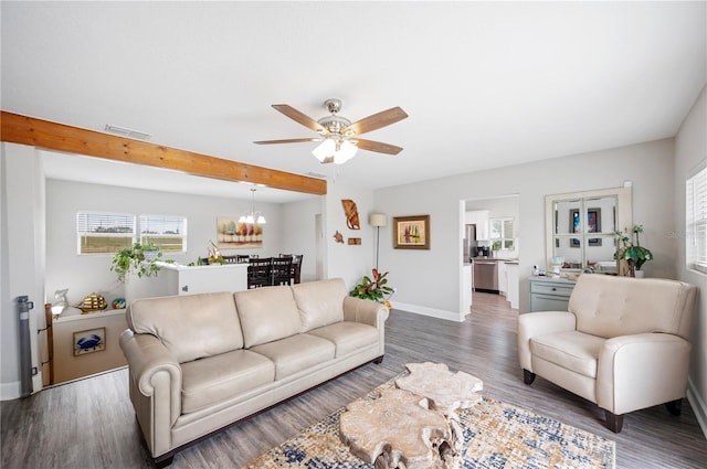 living room with dark hardwood / wood-style flooring and ceiling fan with notable chandelier