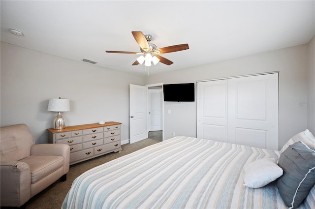 bedroom with dark colored carpet, ceiling fan, and a closet