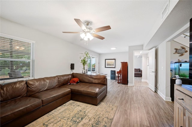 living area featuring visible vents, a ceiling fan, a healthy amount of sunlight, baseboards, and light wood-style flooring