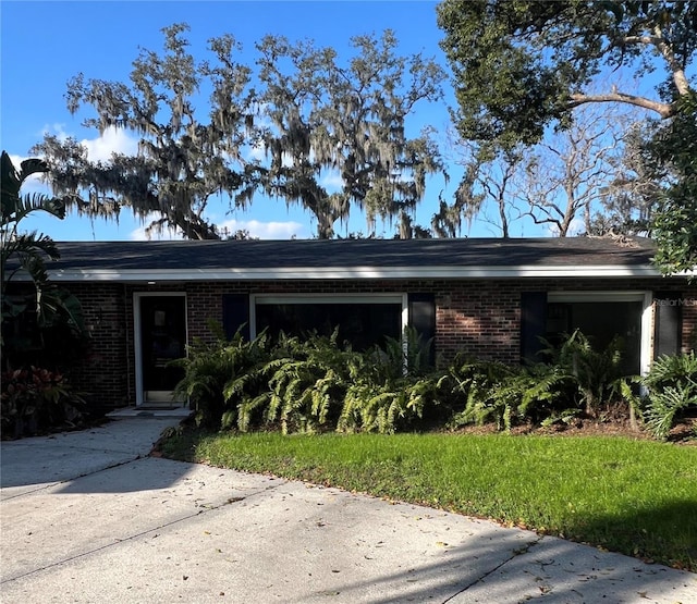 single story home featuring a garage and a front yard