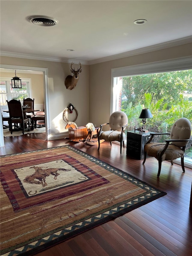 living area with crown molding and dark hardwood / wood-style floors