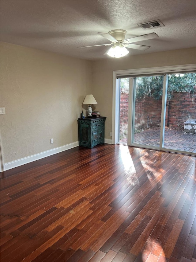 spare room featuring ceiling fan, dark hardwood / wood-style floors, and a textured ceiling