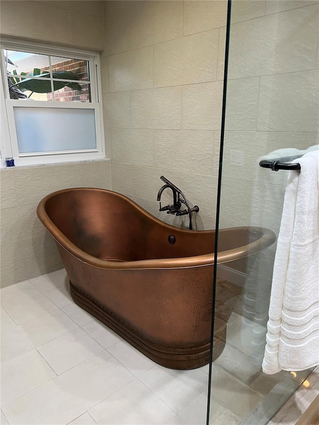 bathroom with tile patterned floors, tile walls, and a tub