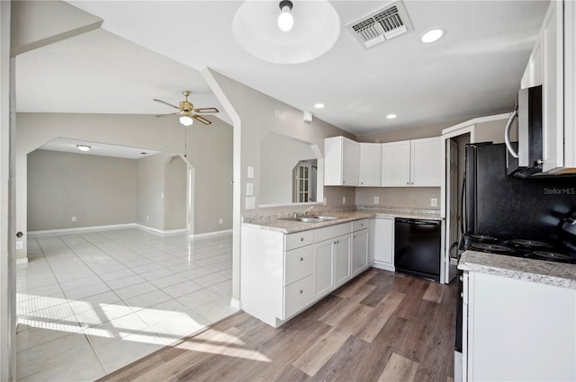 kitchen with electric range oven, white cabinetry, dishwasher, lofted ceiling, and sink