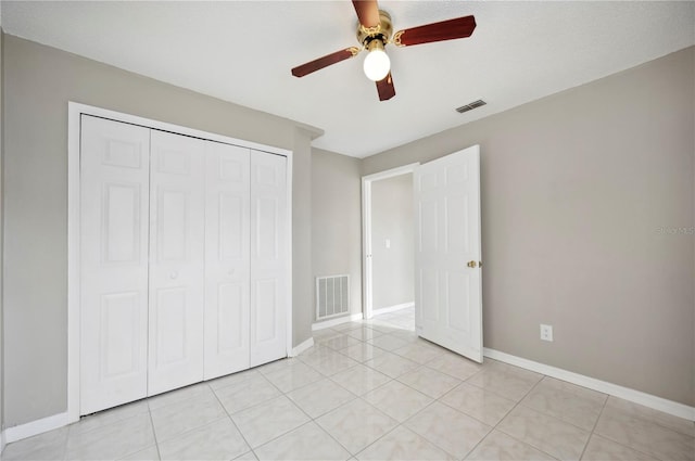 unfurnished bedroom with ceiling fan, a closet, and light tile patterned floors