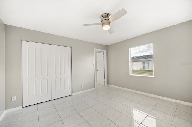 unfurnished bedroom with light tile patterned floors, ceiling fan, and a closet