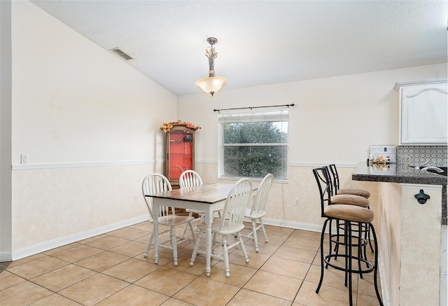 dining area with light tile patterned floors and a textured ceiling