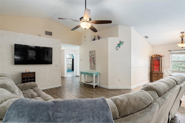 living room featuring dark wood-type flooring, ceiling fan, and lofted ceiling