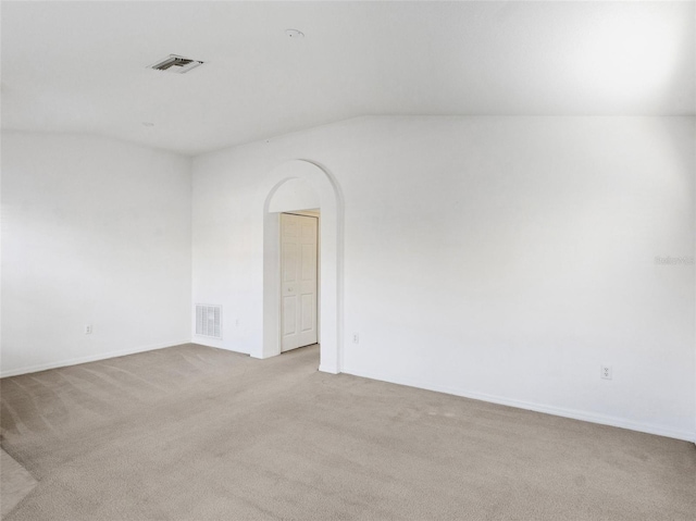 spare room with lofted ceiling and light colored carpet