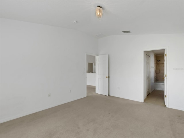 unfurnished bedroom with light carpet and lofted ceiling