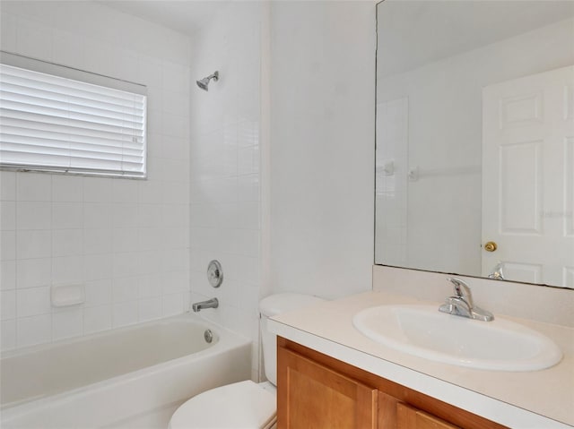 full bathroom featuring vanity, tiled shower / bath combo, and toilet