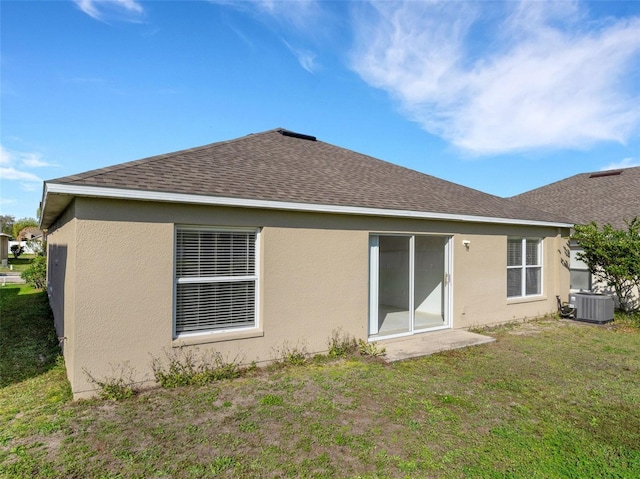 back of house featuring central AC and a yard