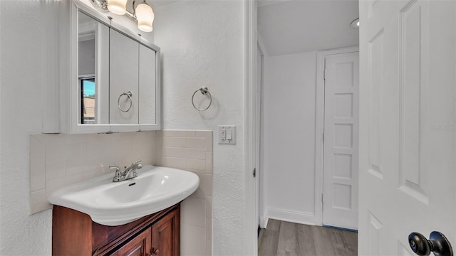 bathroom featuring vanity, decorative backsplash, and wood-type flooring