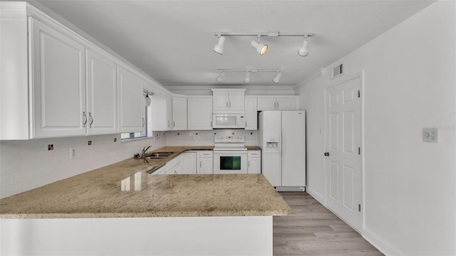 kitchen with sink, white appliances, tasteful backsplash, white cabinets, and kitchen peninsula