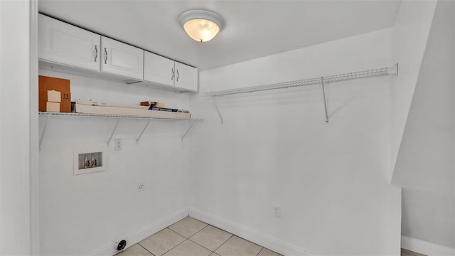 laundry area with cabinets, light tile patterned flooring, hookup for a washing machine, and electric dryer hookup