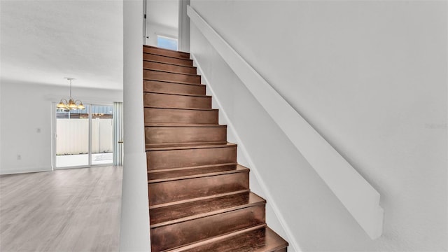 stairway featuring a chandelier and hardwood / wood-style floors