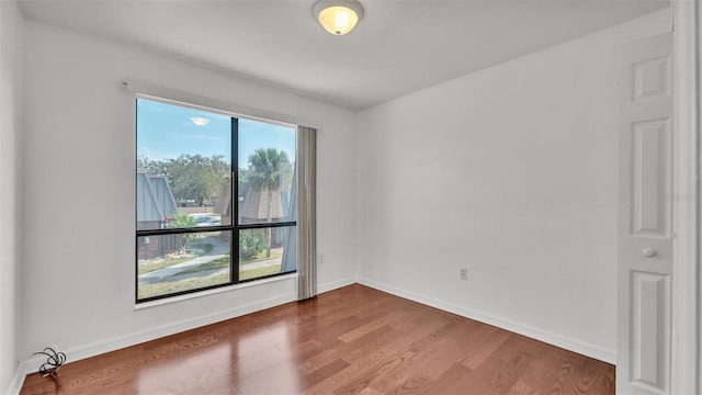 unfurnished room with hardwood / wood-style flooring