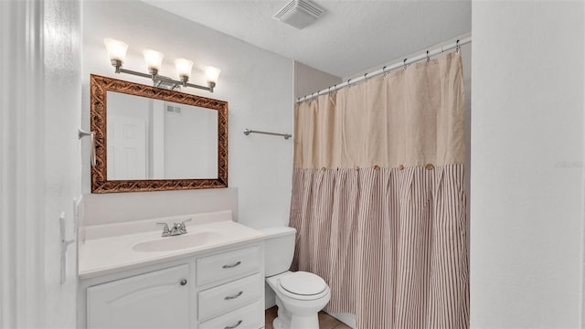 bathroom with vanity, a textured ceiling, and toilet