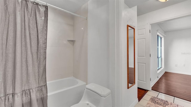 bathroom featuring shower / bath combo and toilet