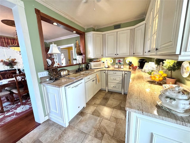 kitchen featuring white cabinetry, sink, ornamental molding, light stone countertops, and white appliances