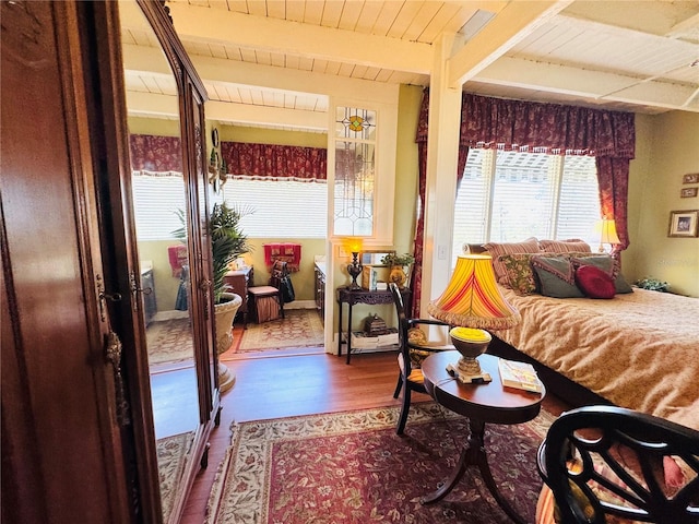 bedroom with beamed ceiling, hardwood / wood-style floors, and wooden ceiling