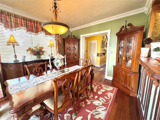 dining space with dark wood-style flooring, crown molding, a textured ceiling, and baseboards