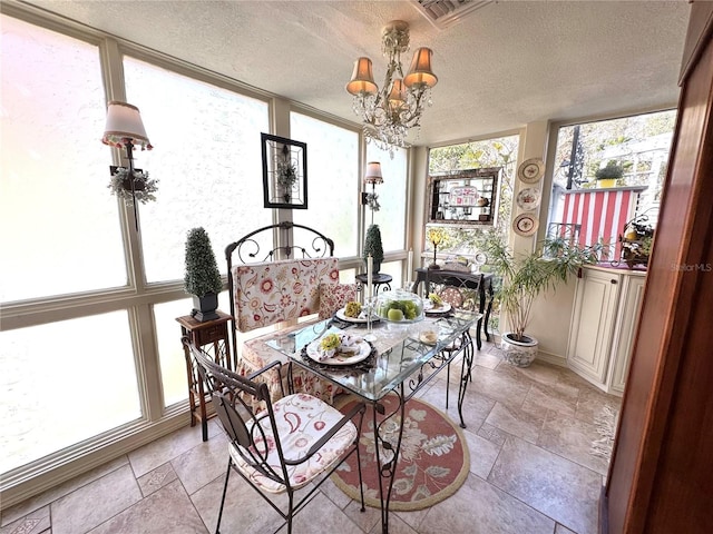 dining area with visible vents, an inviting chandelier, a textured ceiling, stone tile flooring, and floor to ceiling windows